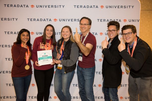 Group of five students and a professor posing as champions with their award Group of five students and a professor posing as champions with their award